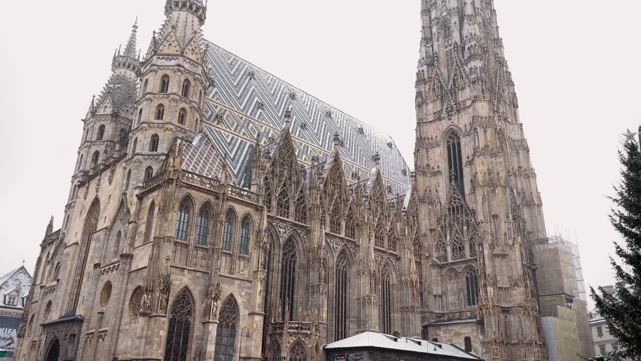 People at a busy Christmas market near the iconic St. Stephen's Cathedral in snowy Vienna