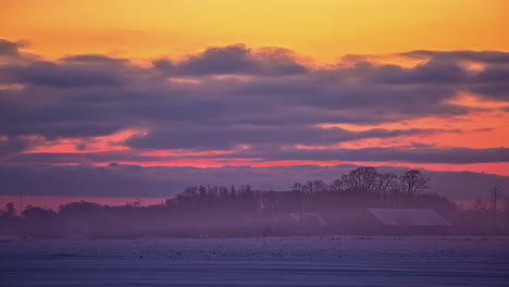 Time-lapse-early-morning-clearing-fog-over-winter-snowy-landscape-near-log-cabin