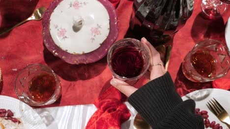 formal dinner party, top-down point of view of picking up a wine glass from the table