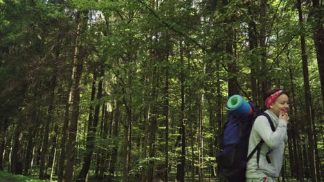 funny tourists stride along road near forest comparing way with map