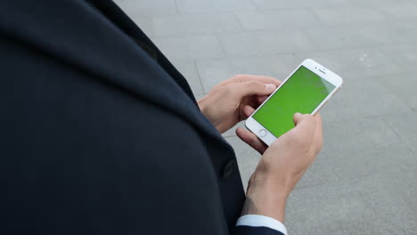 Businessman-using-cellphone-on-urban-street.-Worker-scrolling-smartphone-outside