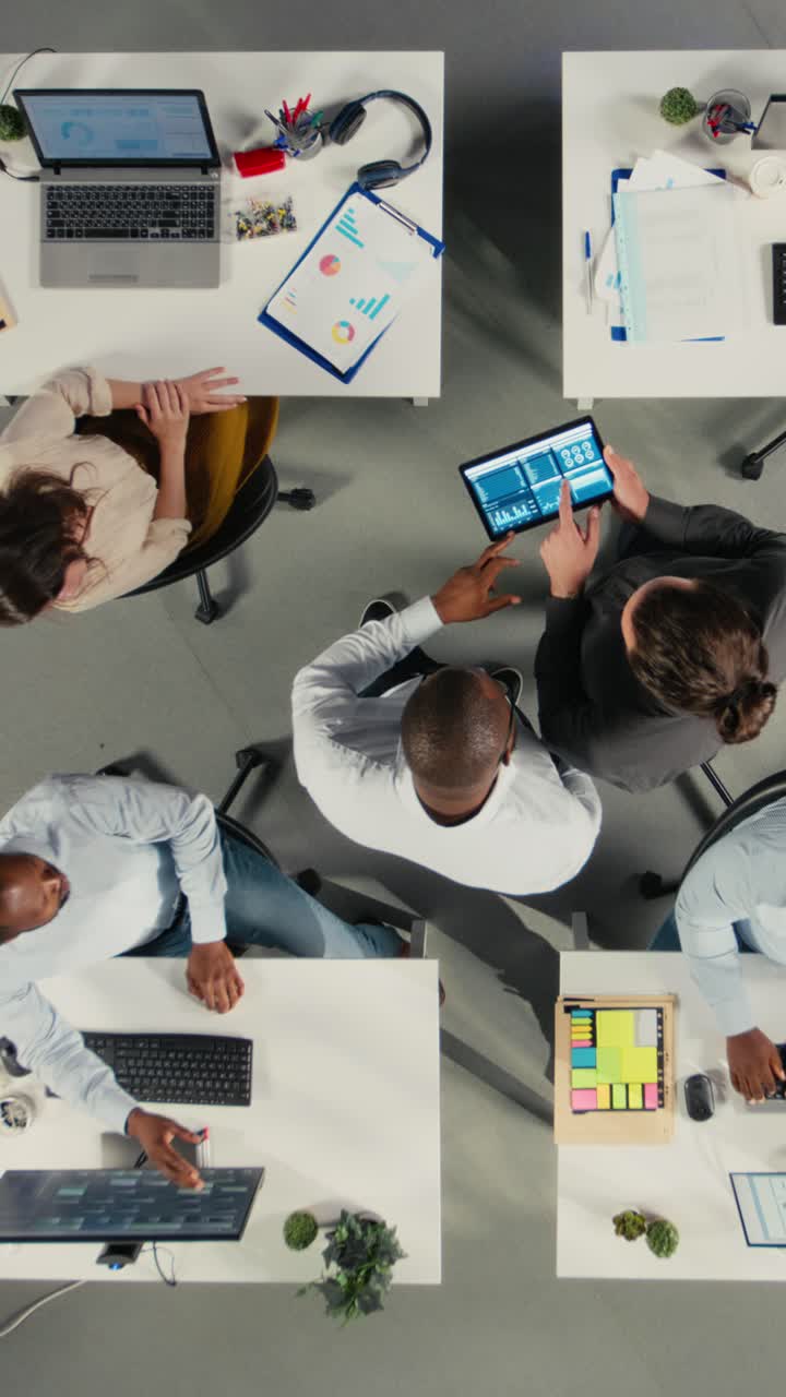Vertical Video Top down view zoom out of work team in multinational company