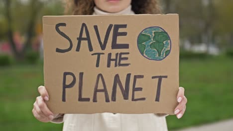 woman with a poster save the planet. feasible contribution to the fight against global pollution of nature. single picket