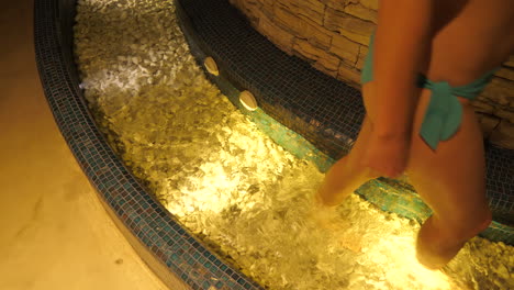 Close-up-feet-of-woman-walking-in-cold-bath-in-wellness-spa