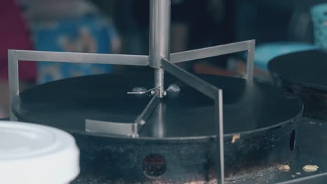 el cocinero rocía agua en la superficie del crepeteador en un primer plano del café