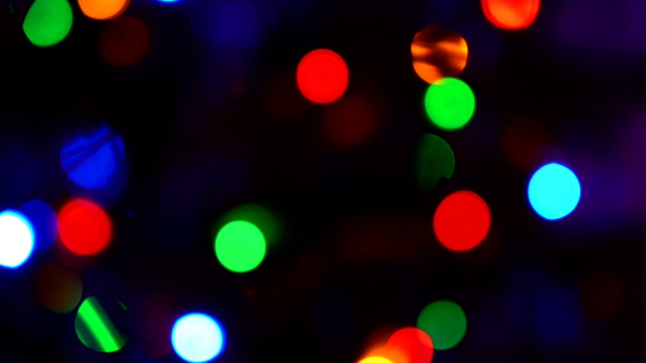 Shimmering abstract colored circles defocused christmas lights background. Blurred fairy lights. Out of focus holiday background christmas tree. Light bokeh from Xmas tree. Xmas and New Year theme. 4k video