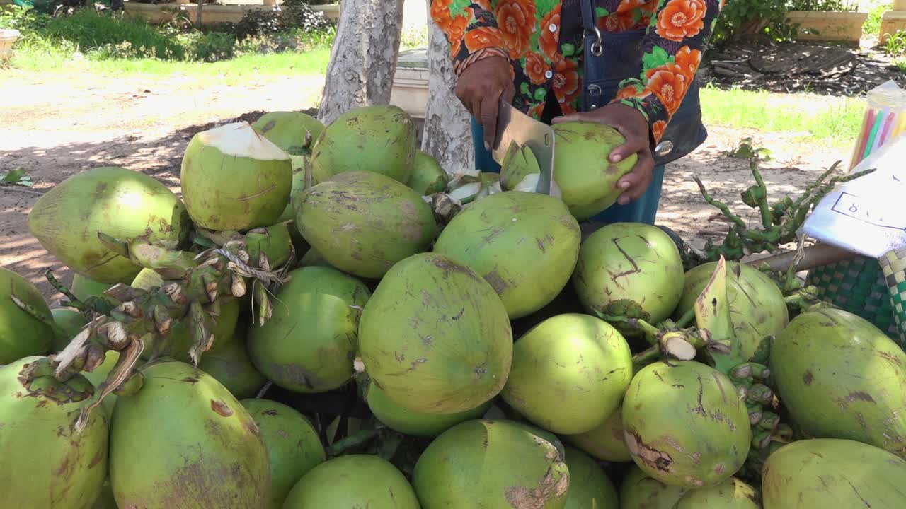 cortando un coco al lado de la calle