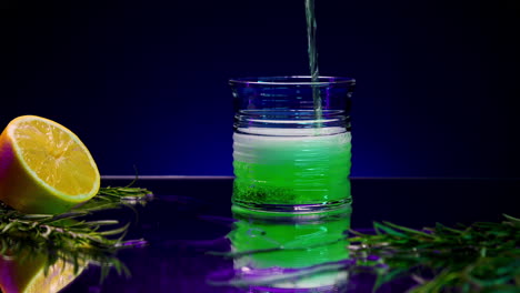 neon green cocktail with lime and rosemary