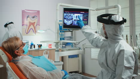 doctor with face shield pointing on stomatological monitor