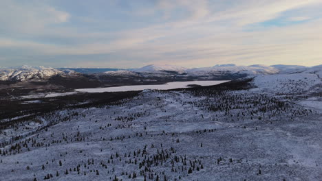 stunning aerial footage of fish lake in whitehorse, yukon. snowy wilderness reflects the serene beauty of sub-zero canadian winters.