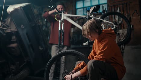 Trabajo-En-Equipo-De-Padre-E-Hijo-En-Taller-De-Reparación-De-Bicicletas