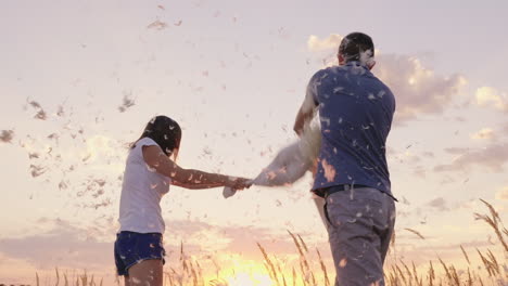 Young-People-Are-Madly-Having-Fun-A-Woman-Is-Beating-Her-Pillow-With-A-Friend-Feathers-Are-Flying-Fi