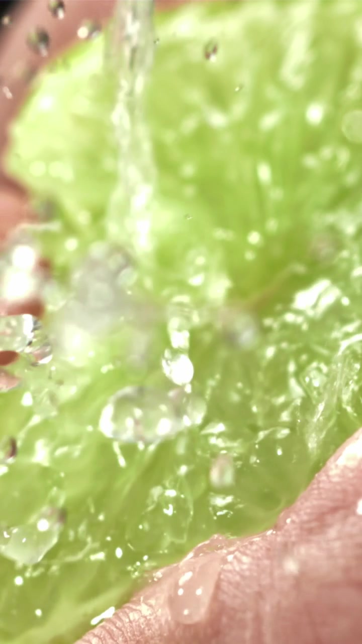 Acqua rinfrescante che schizza su una fetta di lime verde brillante
