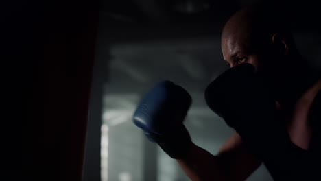 athlete training boxing with punching bag. man working out blows on sports bag