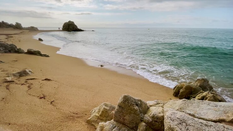 Plage méditerranéenne sans personnes au lever du soleil, eau calme bleu turquoise, côte de Barcelone, Maresme, Costa Brava, Espagne, tourisme européen.