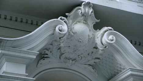 beautiful grey stucco ornament over the window or door on the facade of an old european building, viewed in close-up