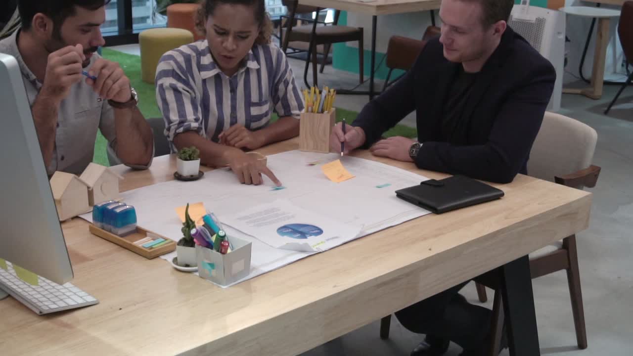 창의적인 사업가 그룹이 직장에서 사무실 책상에서 대화를 나누고 있습니다.