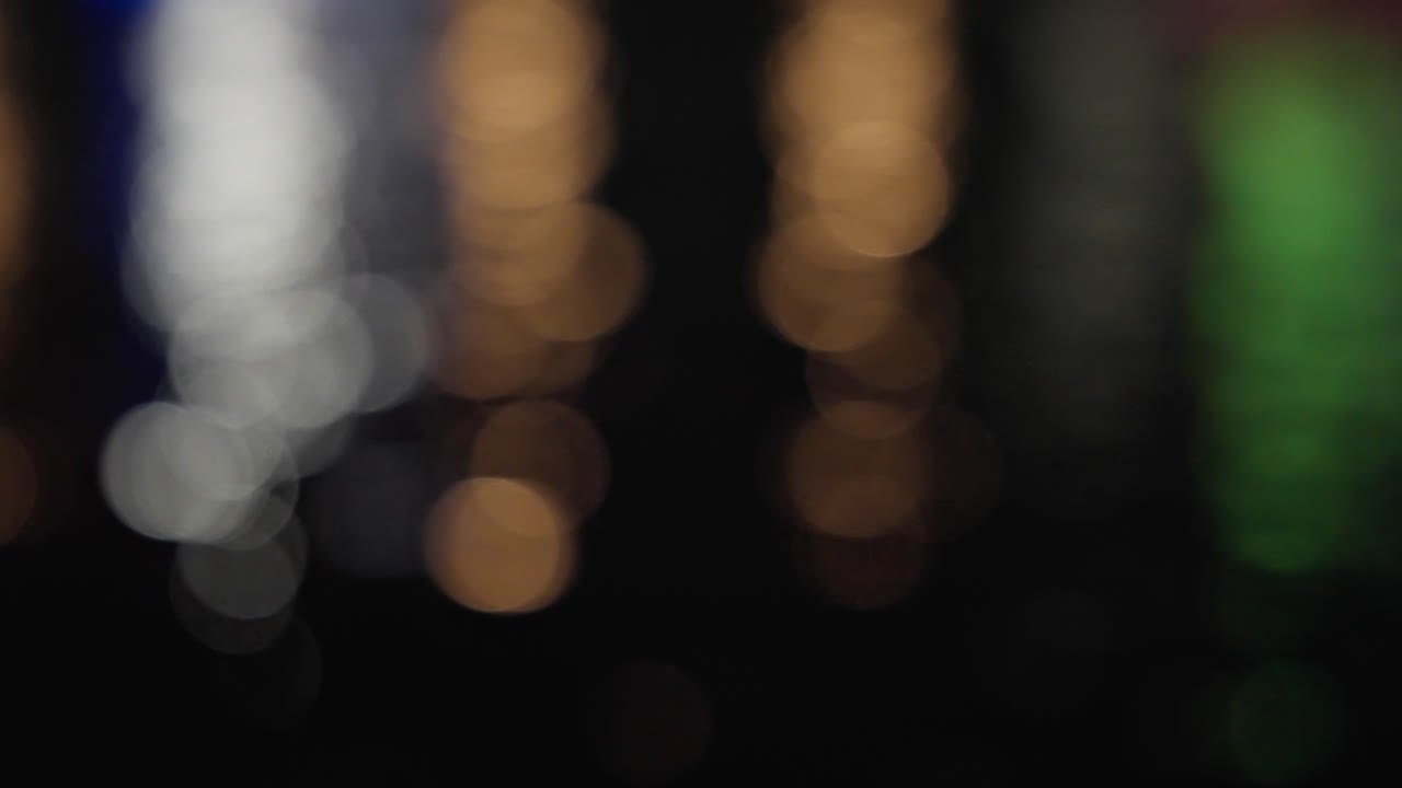 luces de colores desenfocadas brillando en la superficie del agua reflejada por la noche