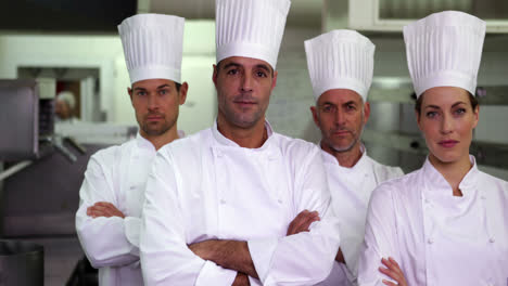 Cuatro-Chefs-Serios-Mirando-A-La-Cámara-Con-Los-Brazos-Cruzados.