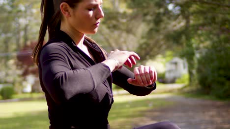 una mujer joven estira sus hombros y se agacha en un parque cercano para un entrenamiento cardiovascular que proporciona salud y diversión