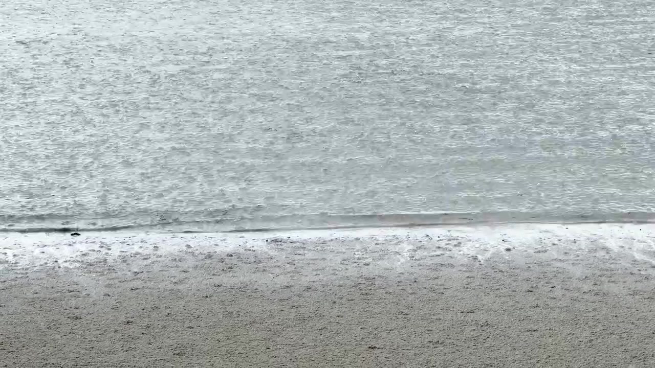 タンザニアのザンジバルにあるビーチで、砂と海水に激しく降る大雨