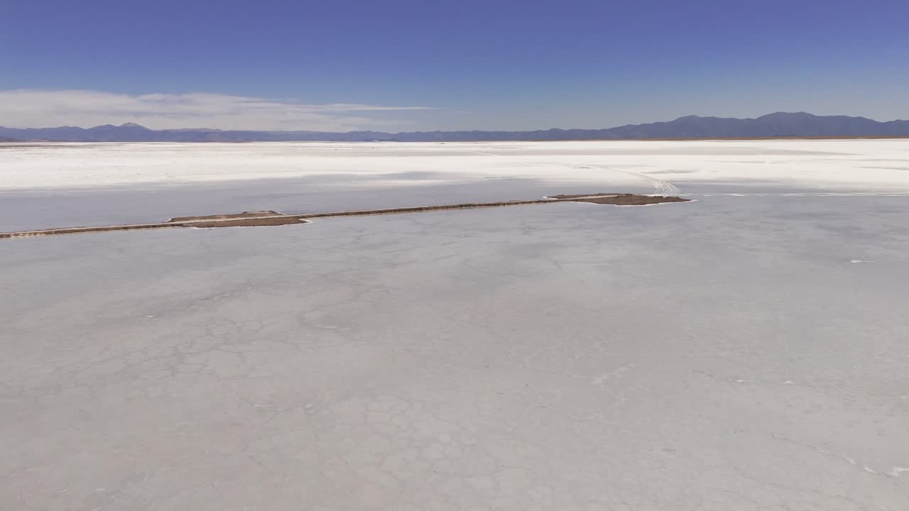 drone aéreo desce e se inclina para cima com vista para a estrada 52 que divide as salinas brancas grandes das províncias de jujuy e salta, argentina