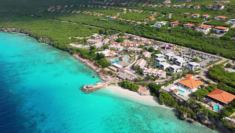 panoramic aerial establishing overview of karakter beach and luxury resort estate behind