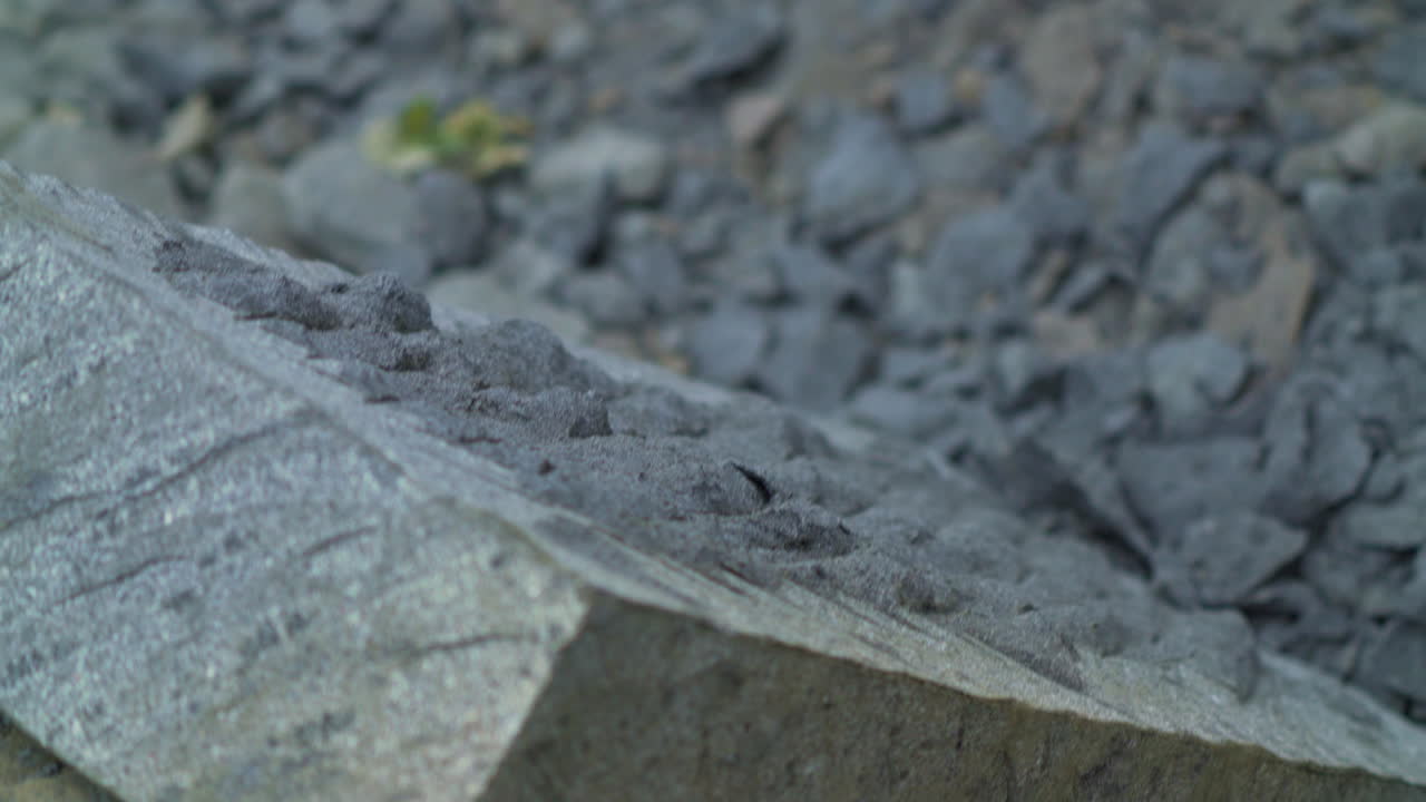 칠로에 섬의 안쿠드 시에 있는 칸카구아 석판을 가장자리로 만들기 위해 픽을 사용하는 장인의 클로즈업 샷