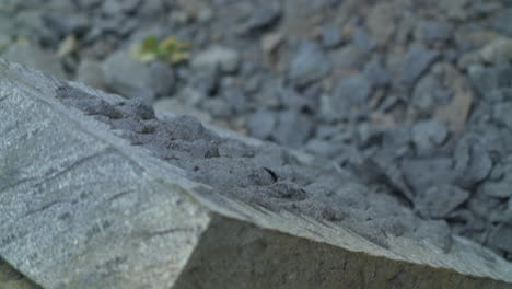 close up shot of a craftsman using a pick to edge a stone slab of cancagua stone in the city of ancud, chiloe island