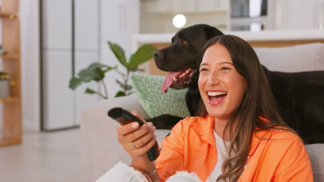 mujer riendo y viendo televisión con su perro