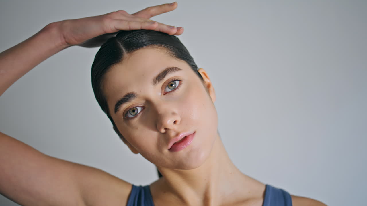Tranquil woman warming head up indoors closeup. Yoga lady face stretching neck