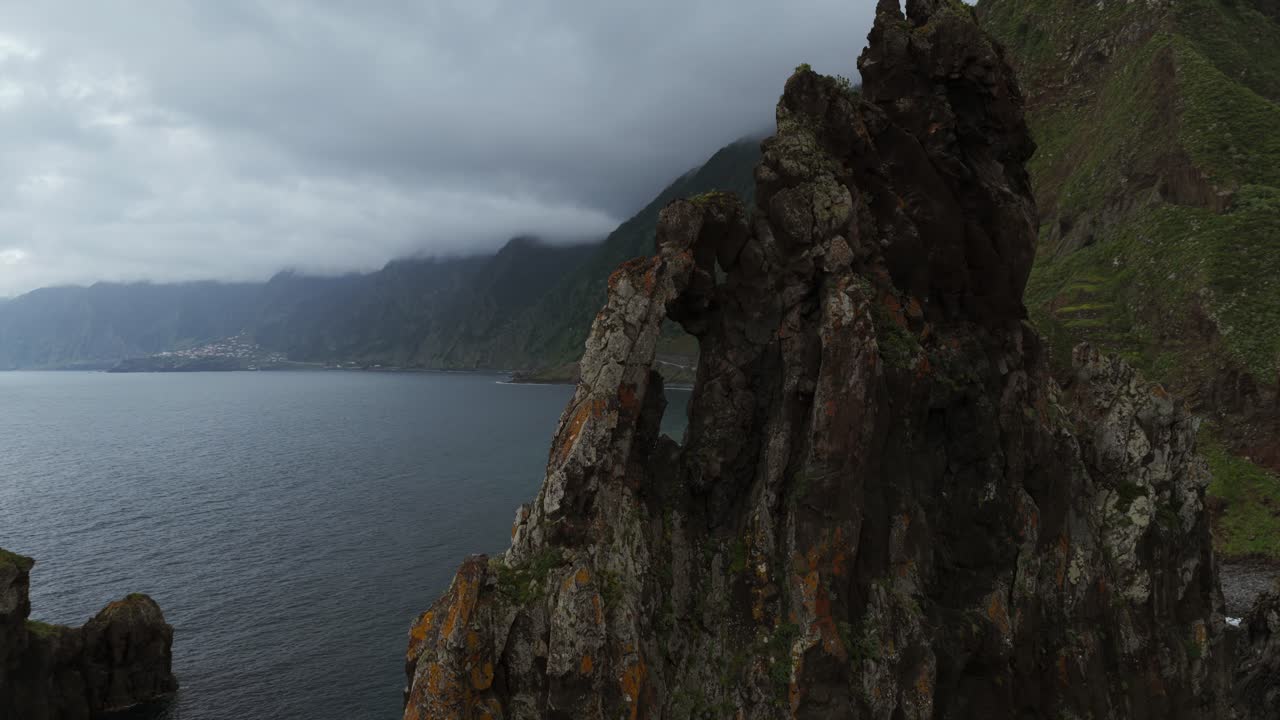 Rocky Coast And Islet Of Ribeira da Janela With Overcast Sky In Madeira, Portugal. pullback drone shot