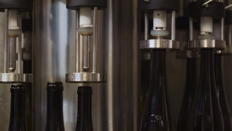 wine bottles lifted by machine and getting filled with wine