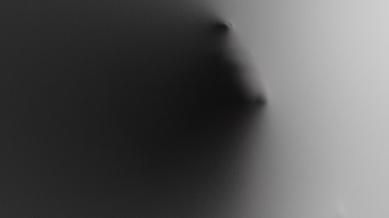 A scary face and hands appear from the white surface