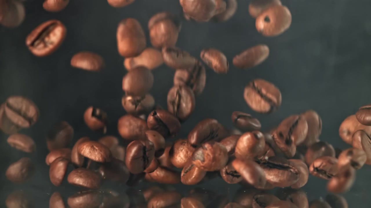 Chicchi di Caffè Tostati che Cadono al Rallentatore su Sfondo Scuro