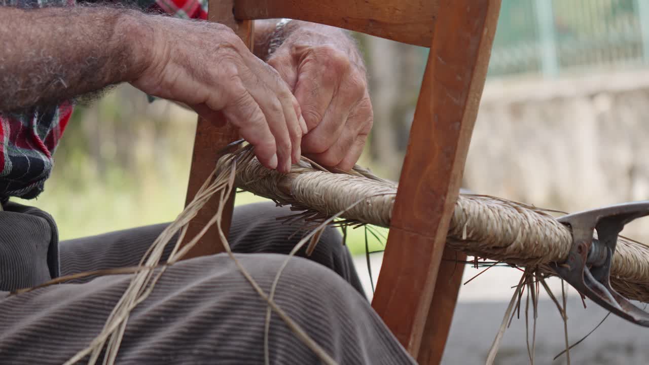 un vistazo más detallado sobre el tejido de manos en el trabajo manual al hacer una silla de mimbre, italia.