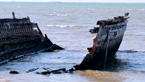 waves crash against a decaying shipwreck