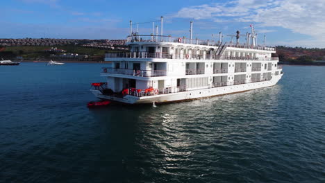 aerial drone shot slowly rising upward of a centara mirage passenger boat anchored in mui ne, vietnam