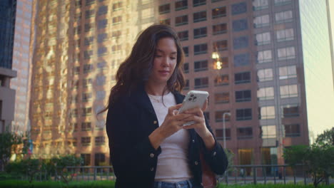 mujer joven hace fotos de la ciudad en el teléfono inteligente. chica asiática usando el teléfono tomando fotos