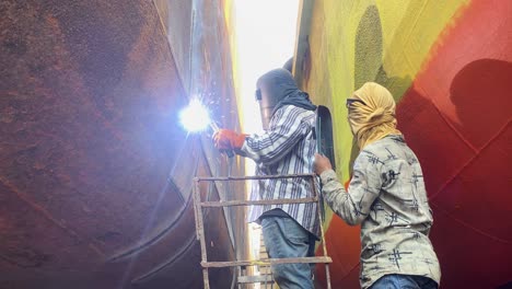 Trabajadores-Soldando-Cascos-De-Barcos-En-Un-Sitio-De-Construcción-Naval-En-Dique-Seco-En-Bangladesh