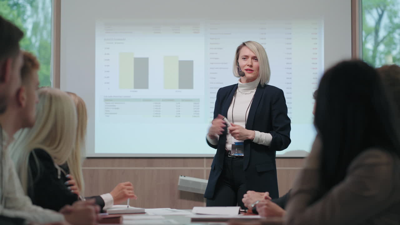 la mujer jefe está hablando en frente de los jefes de departamentos y especialistas de la empresa