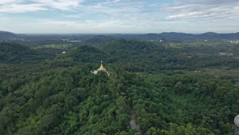 phra maha chedi thep nithakorn, un templo dorado en la cima de una ladera con árboles verdes del bosque, saraburi, tailandia