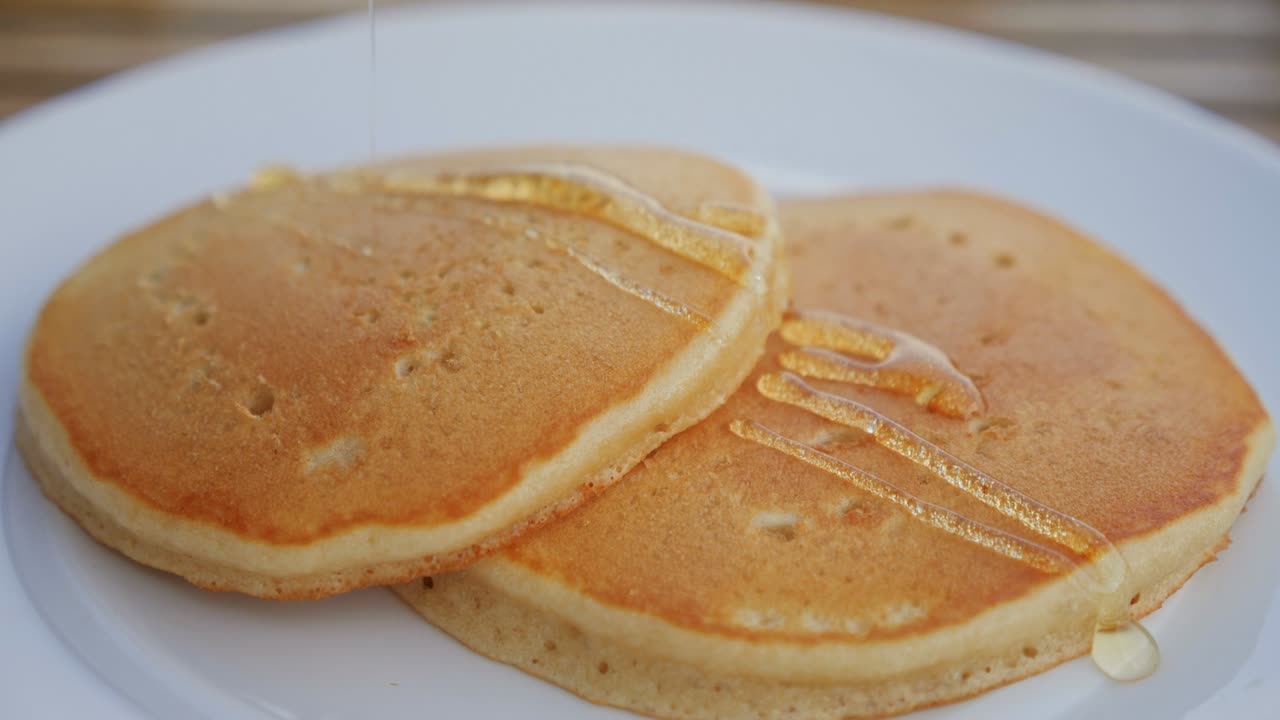 miel vertiendo en un panqueque. panqueque con jarabe de arce caliente, comida dulce para el desayuno, comida no saludable. comida azucarada
