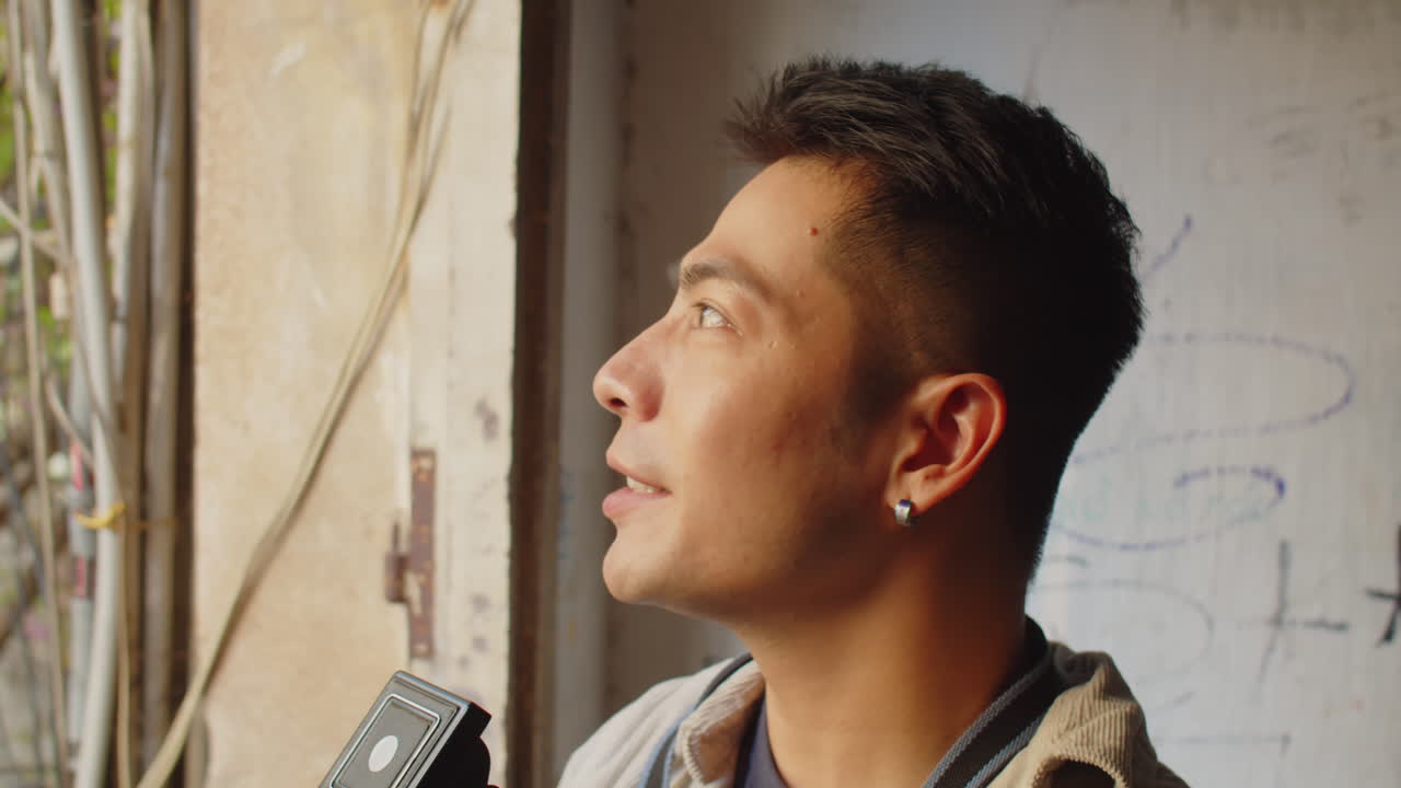 Male Photographer Filming on Retro Camera inside Abandoned House