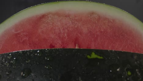 a backwards dolly movement revealing a fresh watermelon, from the red soft flesh inside to the hard green peel outside