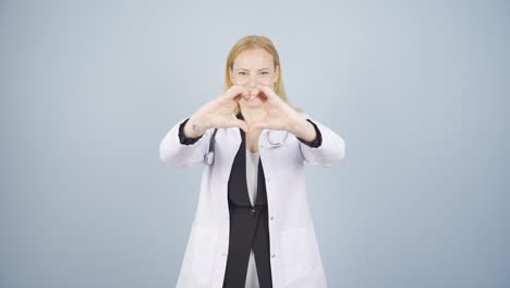 Doctor-making-heart-looking-at-camera.