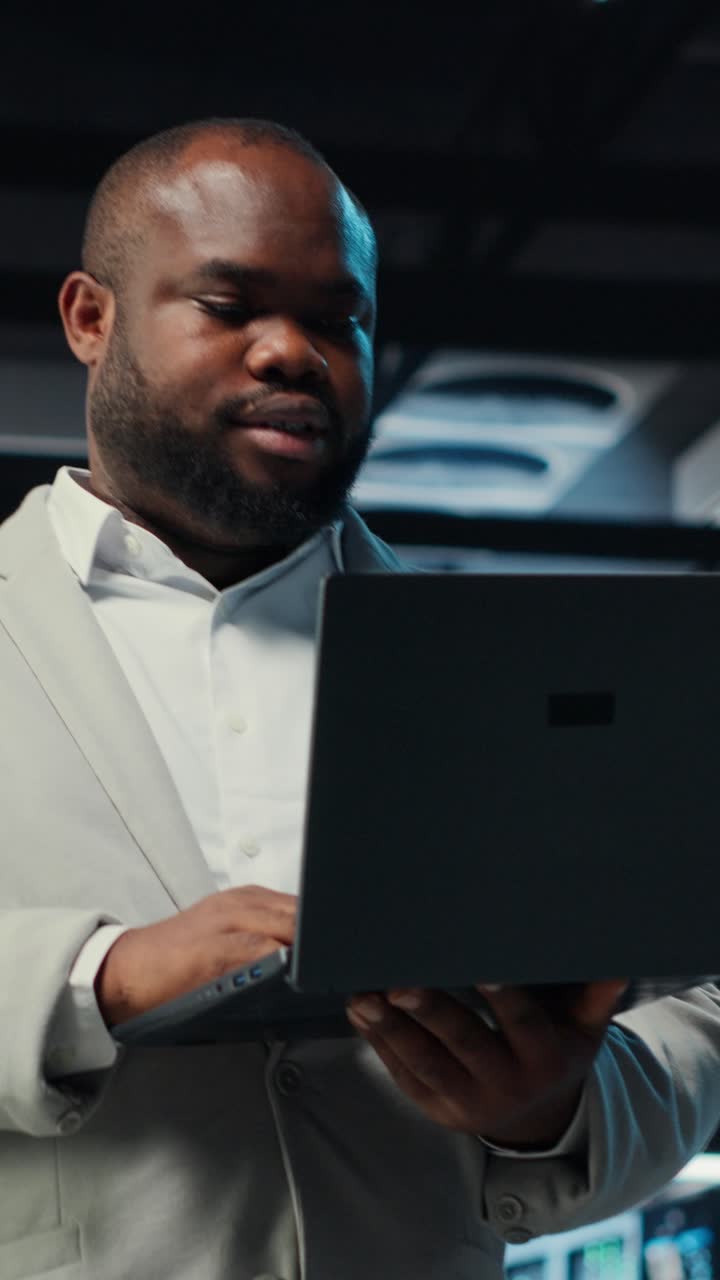 Vertical video Engineer walking in server room backing up storage arrays using software