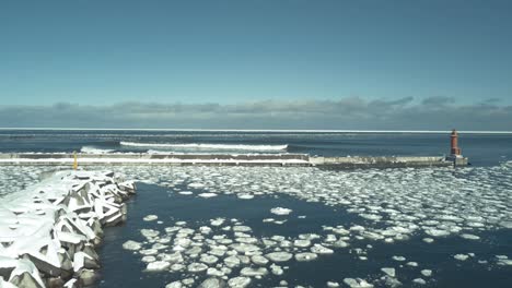 winter waves crashing on icy coastline with lighthouse