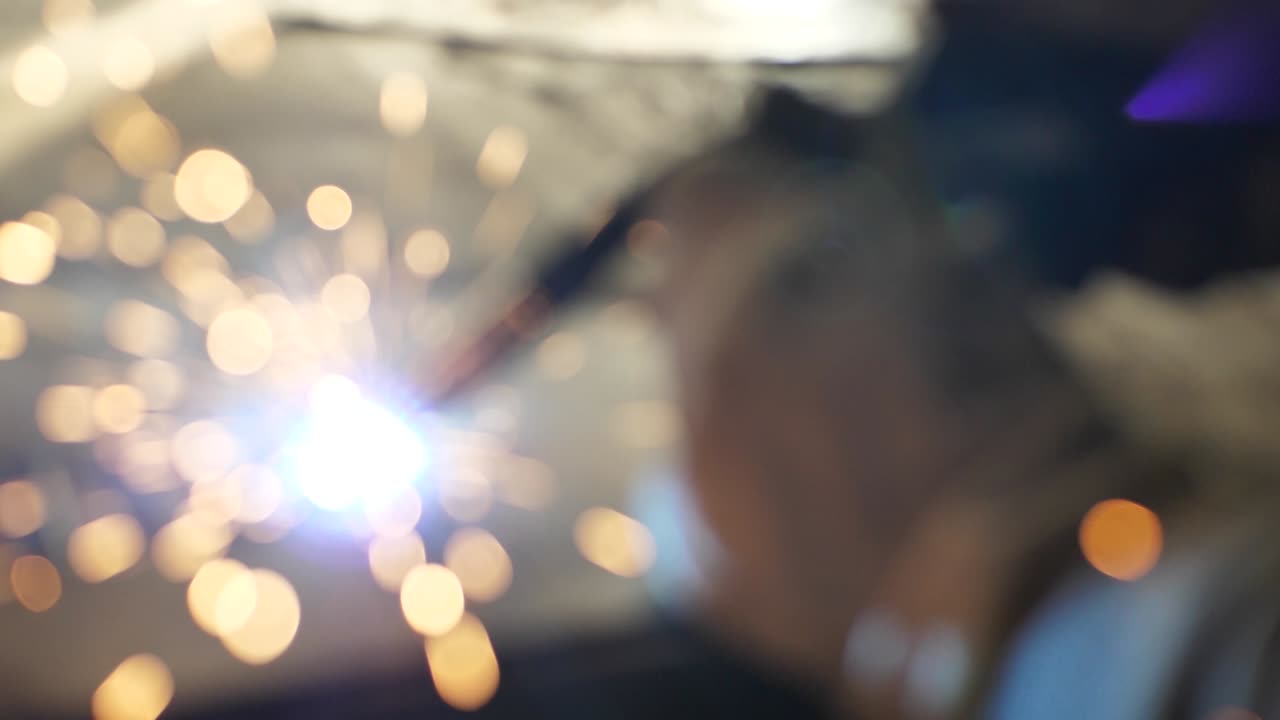 soldador en la mesa suelda un conjunto de piezas metálicas