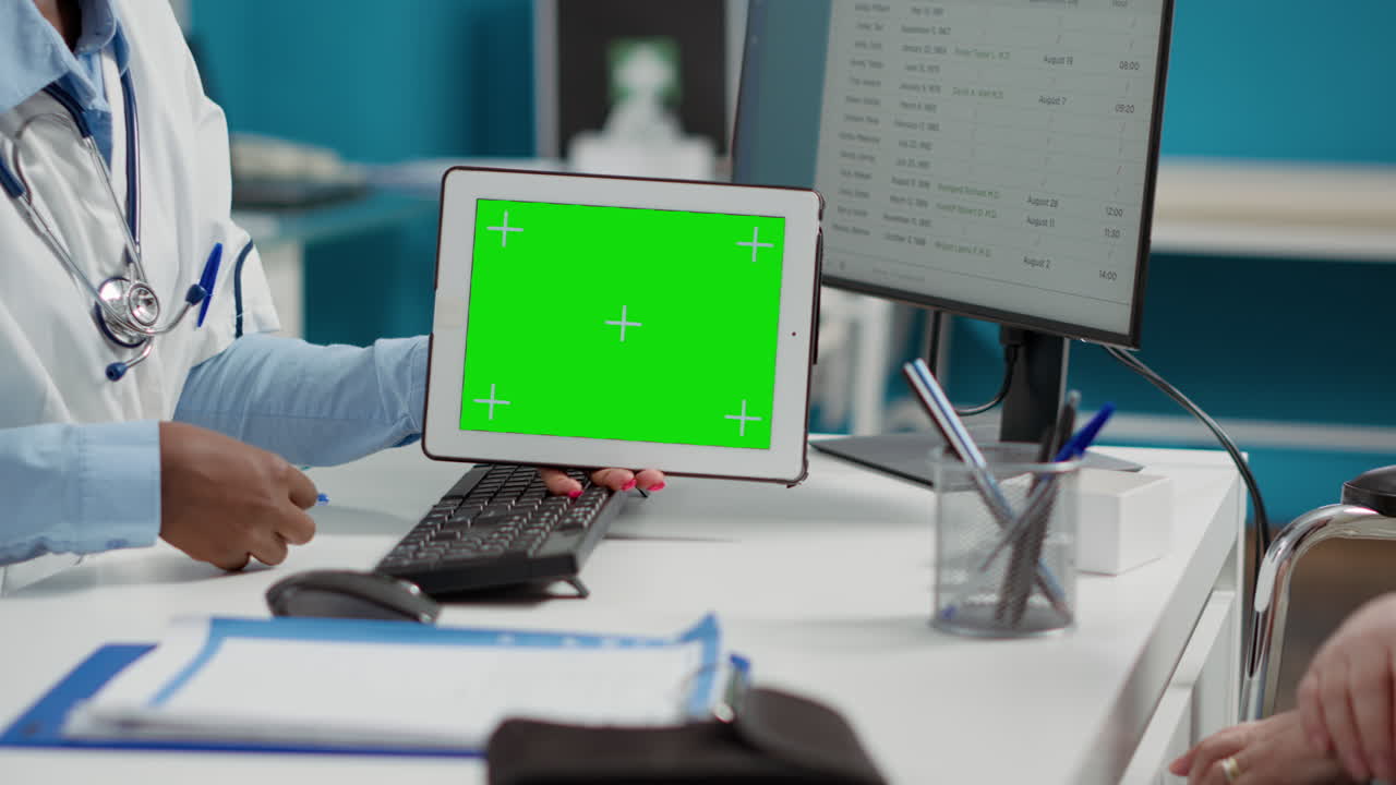Medical professional using a tablet with a green screen